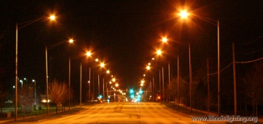 Empty roadway illuminated by streetlights.